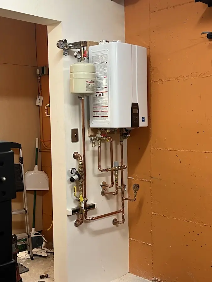 Plumbing technician inspecting water heater connections in Verona